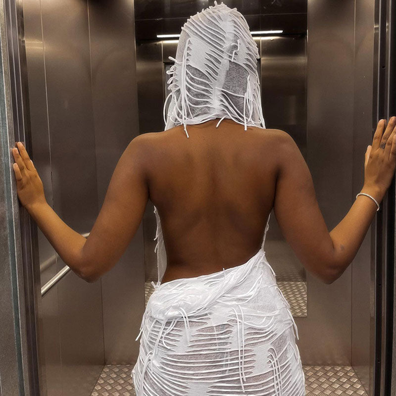 Back view of a woman in a white hooded shredded knit dress