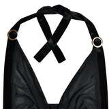 Detail of the velvet halter straps and metal rings on a black sheer mesh dress.