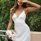 Close-up of the V-neckline and lace trim on a white midi dress.