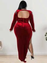 Back view of a woman in a red velvet dress with an open back detail and high slit.