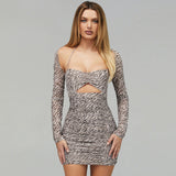 Front view of a woman in a long-sleeved ruched mini dress with an animal print pattern.