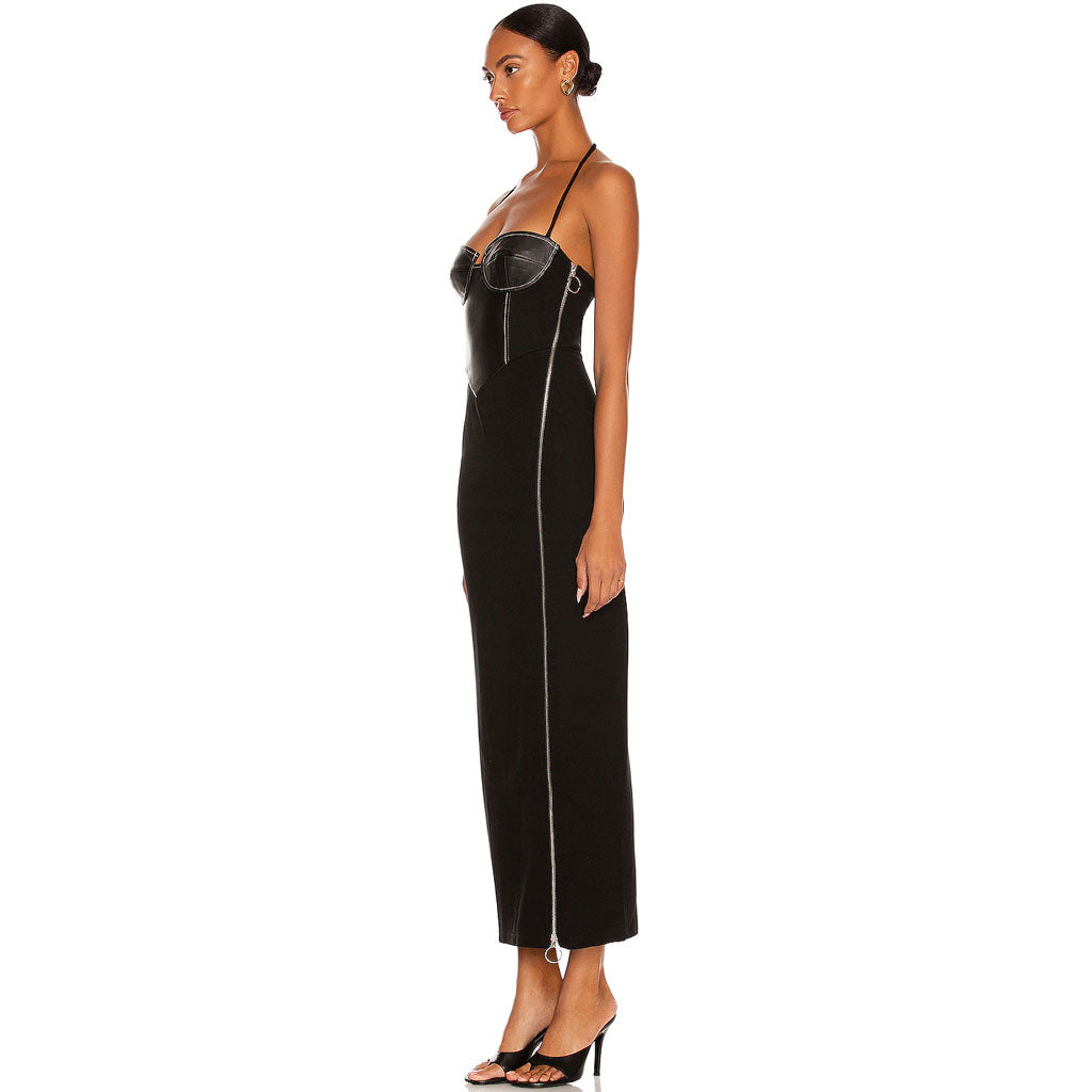 Side profile studio shot of a woman in a black halter dress with a corset bodice and thigh-high slit.