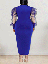 Back view of a woman in a royal blue sheath dress with sheer puff sleeves