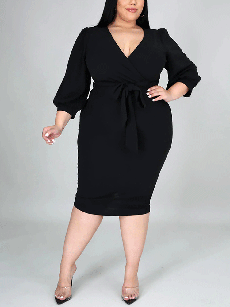Woman wearing a black wrap dress with a self-tie belt and puff sleeves.