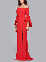 Side view of a woman in a red off-the-shoulder mermaid gown with bell sleeves and a high slit, against a gray background.