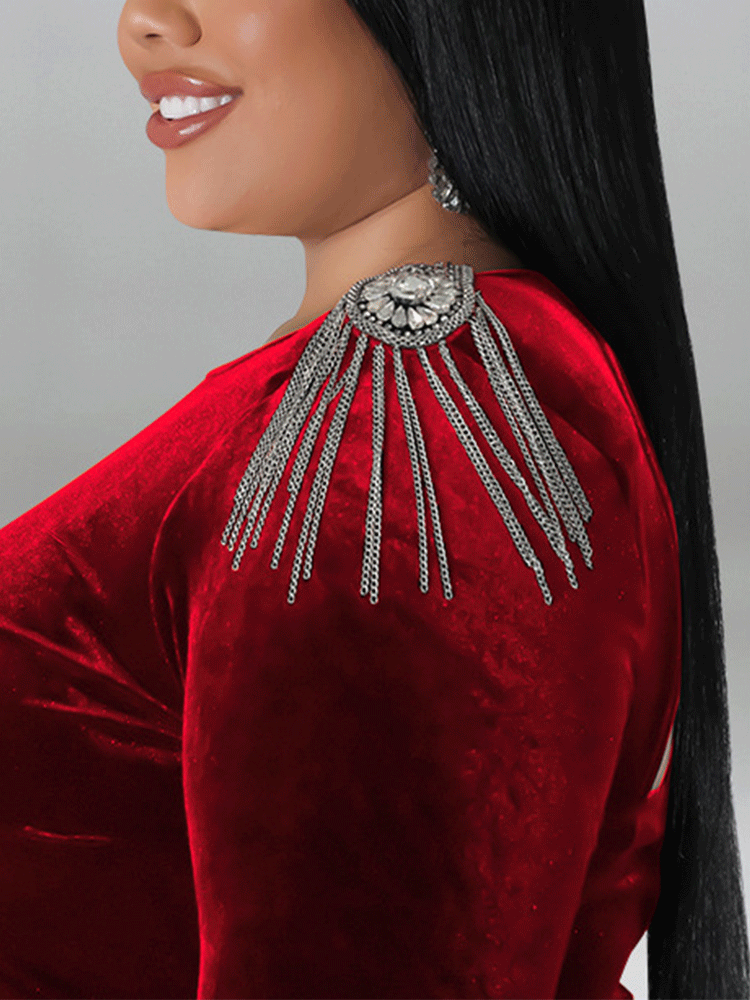 Close-up of the embellished shoulder detail on a red velvet dress.
