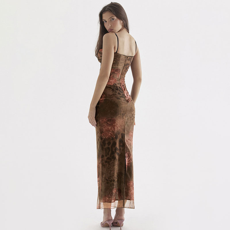 Back view of a woman in a long, sheer mesh dress with a floral and animal print and a ruched bodice.