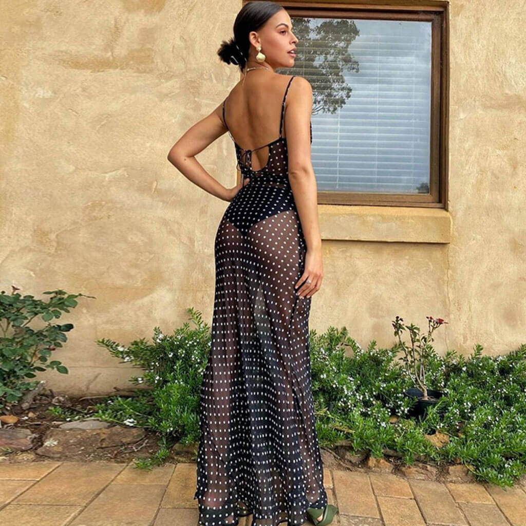 back view of a woman in a sheer polka dot maxi dress with spaghetti straps