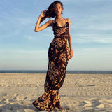 woman wearing a black floral print maxi dress standing on a beach