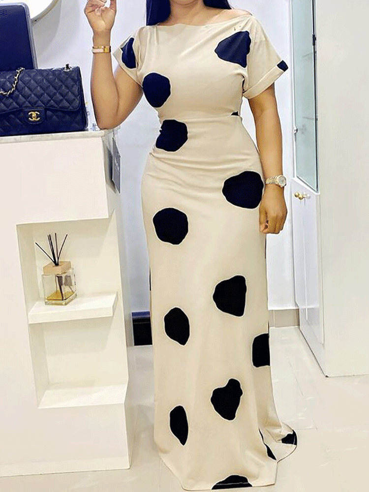 Front view of a woman posing in a cream and black polka dot maxi dress.