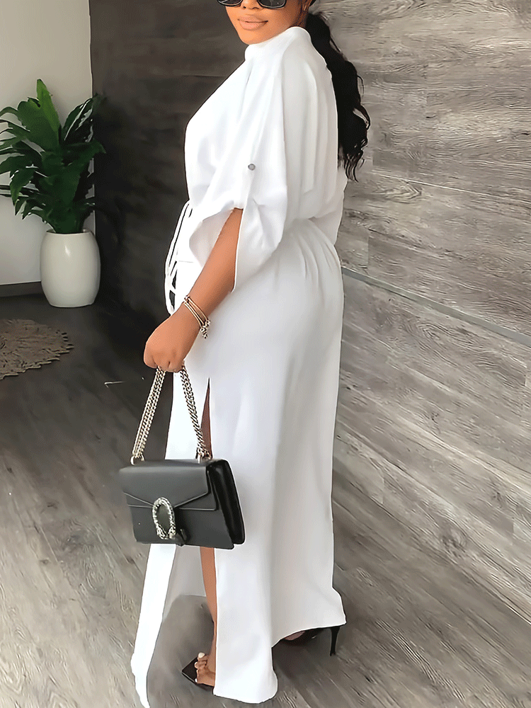 Side view of a woman in a white maxi dress, showcasing the side slit and sleeve detail.