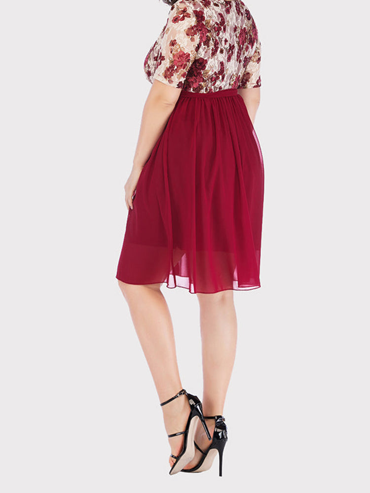 Back view of a plus size woman in a burgundy floral print lace wrap dress